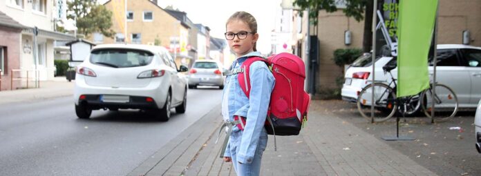 Schulkind möchte eine stark befahrene Strasse überqueren